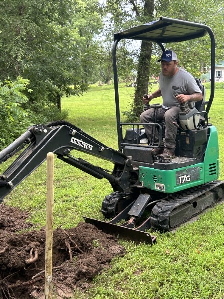John Deere mini excavator digging a sewer trench in Vernon County, Missouri John Deere mini excavator digging a sewer trench in Vernon County, Missouri